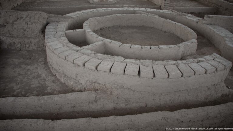Excavated circular earthen feature with low radial mud-brick partitions forming repeated segments at Ancient Sarazm.