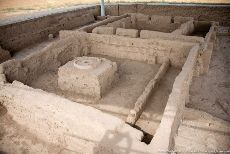 Excavated mud-brick room at Sarazm with low walls and a rectangular block centered on the floor.