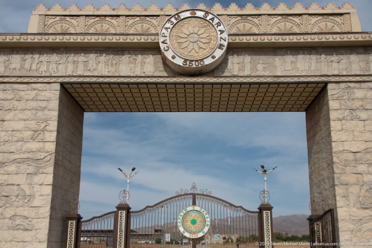 Rectangular pale-stone gateway with a central opening topped by a circular Sarazm emblem at Ancient Sarazm.