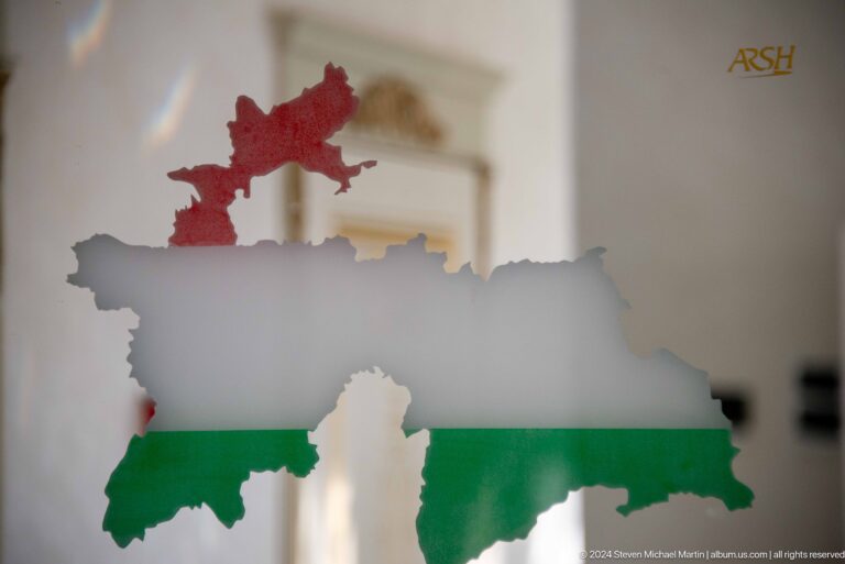 Map silhouette of Tajikistan in national flag colors.