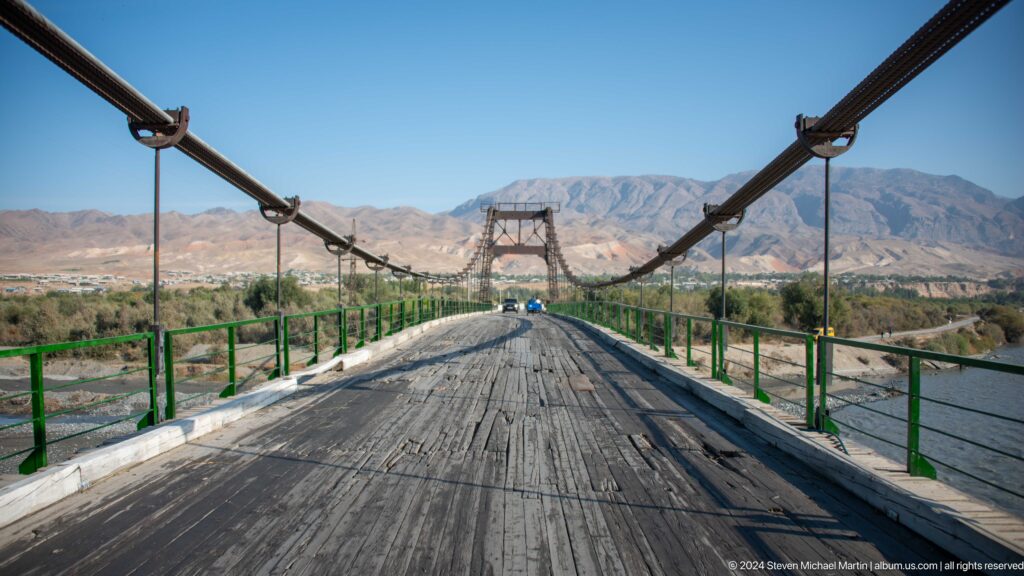 Suspension bridge roadway centered between cables.