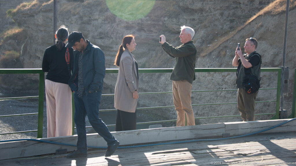 Travelers standing on a bridge above the river.
