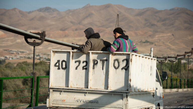 Workers riding in an open utility vehicle.