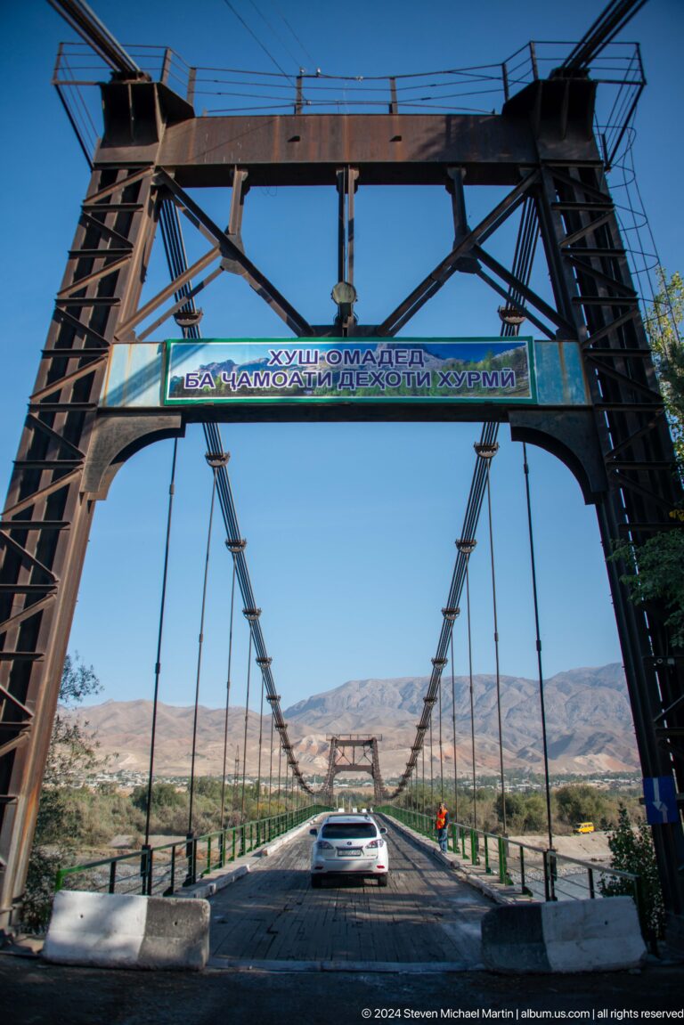 Bridge portal with blue Tajik and Cyrillic signage.