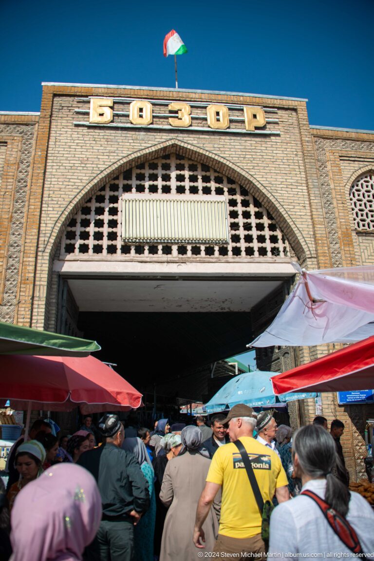 Arched brick market entrance with patterned ventilation screen.