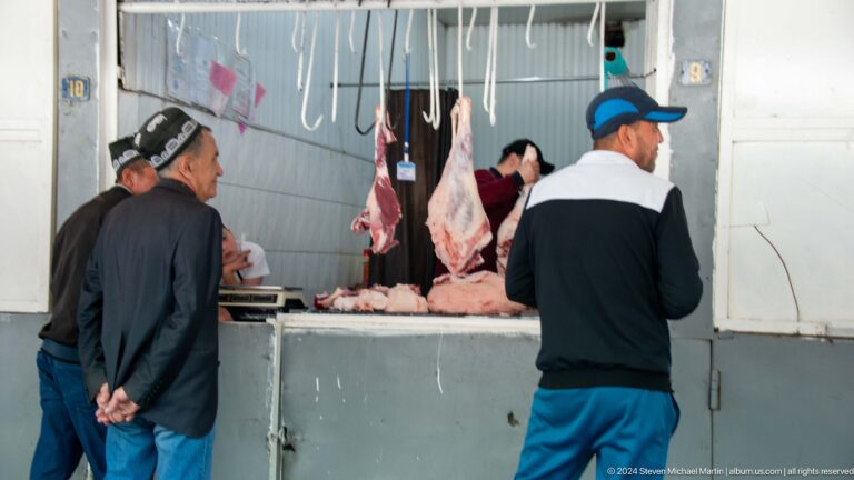 Butcher stall with hanging cuts of meat.