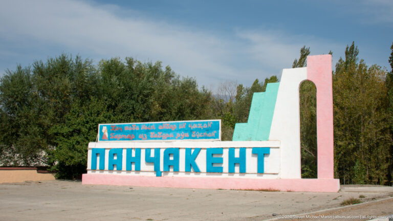Colorful roadside PANJAKENT monument sign.