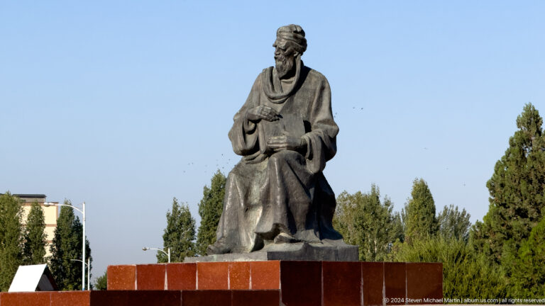 Seated monumental statue of a robed historical figure.