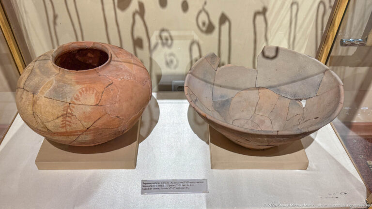 Reconstructed reddish jar and shallow gray-buff bowl displayed side by side.