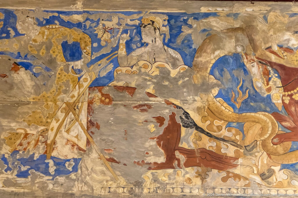 Fragmentary blue and ocher mural showing a human figure beside a horse.