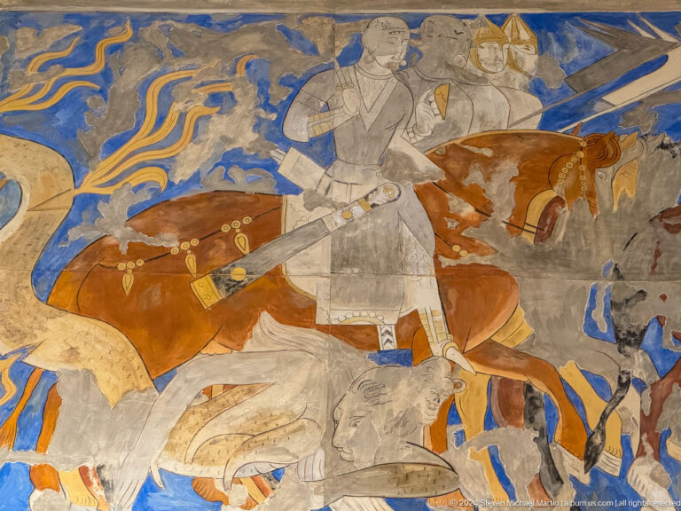 Standing armed figure beside a brown horse and a fallen pale figure in a mural.