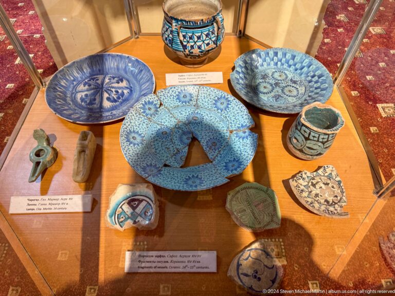 Blue-and-white glazed bowls, plates, and ceramic fragments arranged on a table.