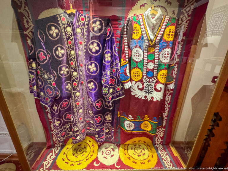 Two richly embroidered purple and black robes with bright yellow and green trim.