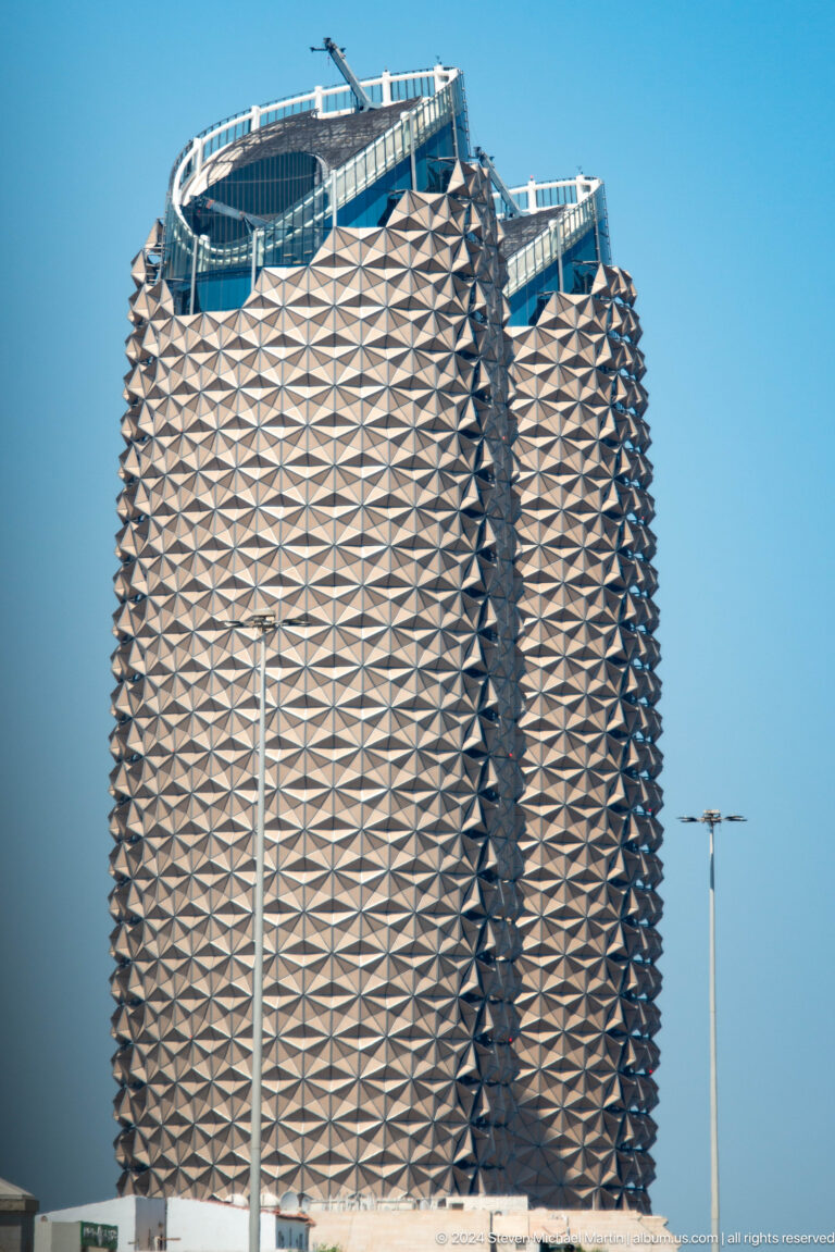 Close-up of Al Bahr Towers’ curved facade in Abu Dhabi, covered with hundreds of repeating triangular shading modules inspired by mashrabiya screens.