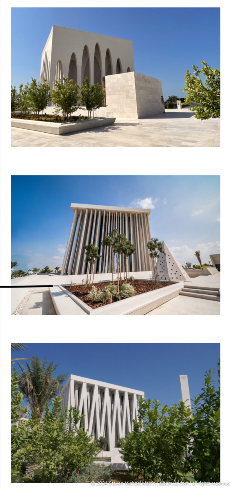 Exterior views of cube-like white buildings with tall arches and vertical fins in a landscaped plaza in Abu Dhabi.