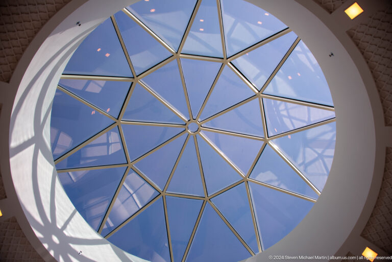 Round skylight with gold radial framing and blue glass panes.
