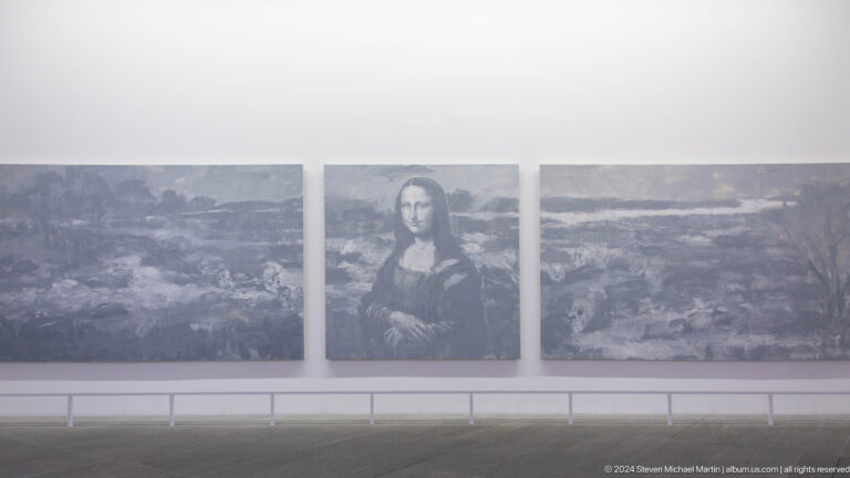 Mona lisa reproduction across triptych wall display at Louvre Abu Dhabi.