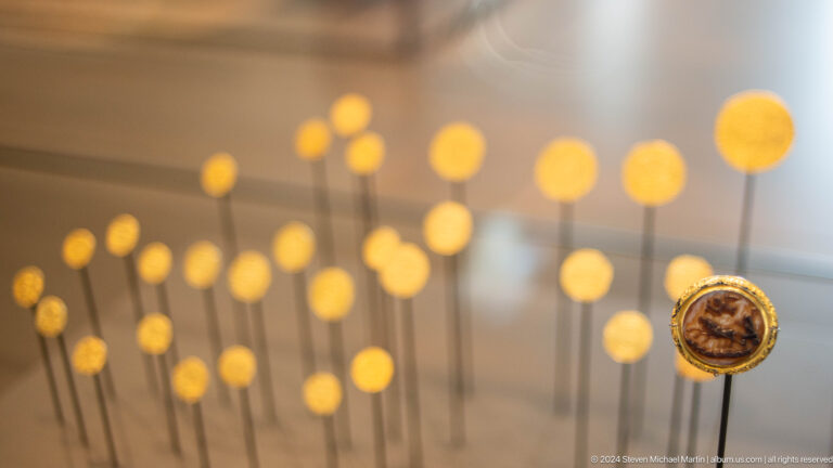 Small suspended object among glowing circular lights at Louvre Abu Dhabi.