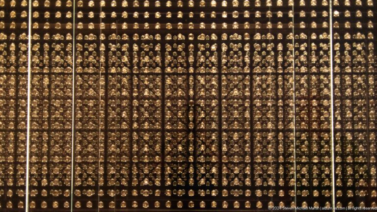 Large perforated metal screen patterned with repeated motifs at Louvre Abu Dhabi.