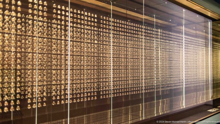 Long illuminated perforated wall in gallery corridor at Louvre Abu Dhabi.