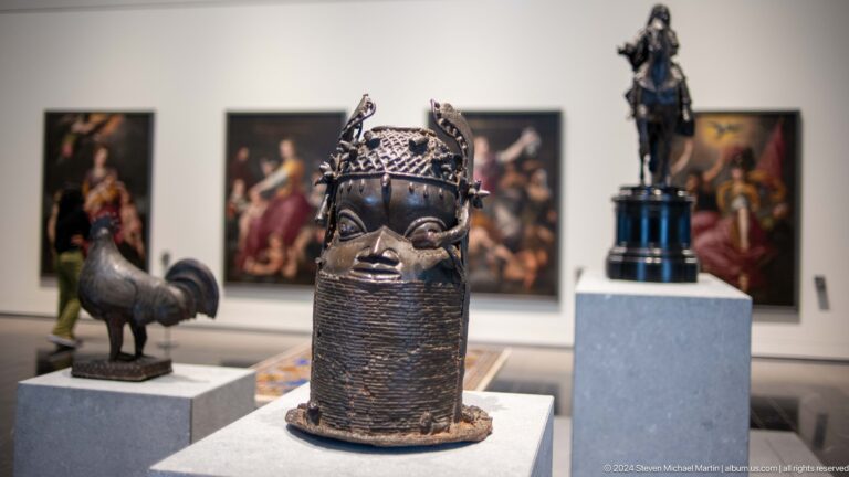 African sculptural vessel with modeled face and crown at Louvre Abu Dhabi.