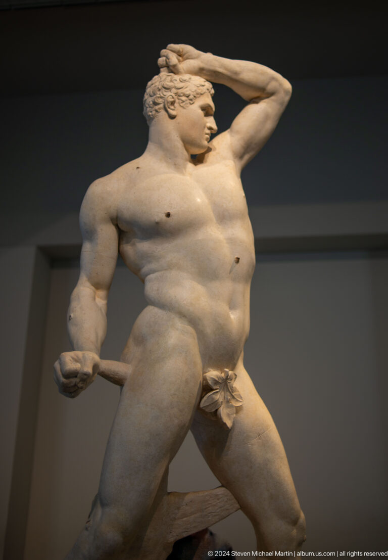 Marble male nude holding club or staff at Louvre Abu Dhabi.