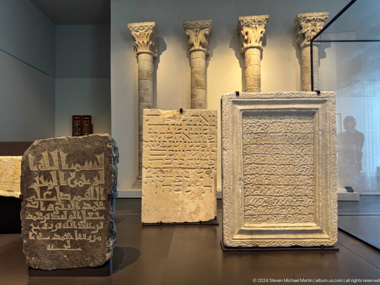 Three inscribed stone slabs displayed upright at Louvre Abu Dhabi.