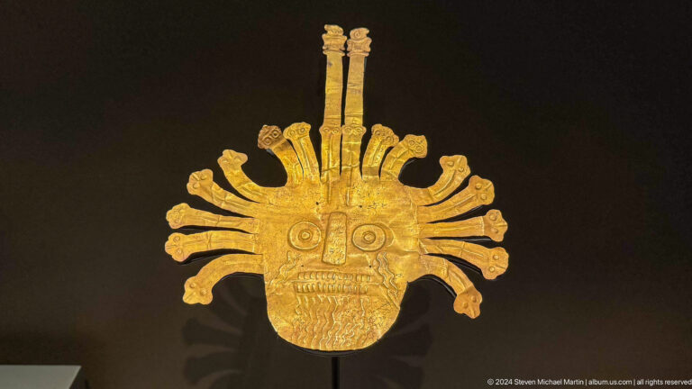 Gold mask with radiating headdress at Louvre Abu Dhabi.