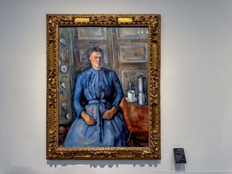 Framed portrait of seated woman in blue dress at Louvre Abu Dhabi.