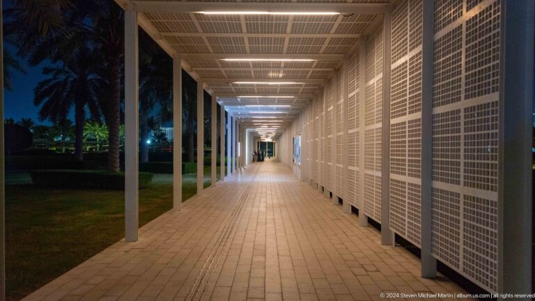 Long perspective down gridded exterior corridor at Louvre Abu Dhabi.