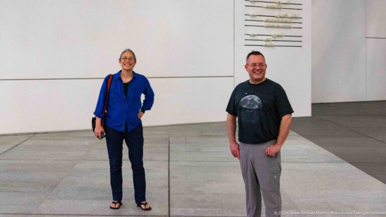Two visitors standing in gallery space at Louvre Abu Dhabi.