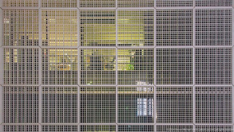Close view of illuminated metal lattice screen at Louvre Abu Dhabi.