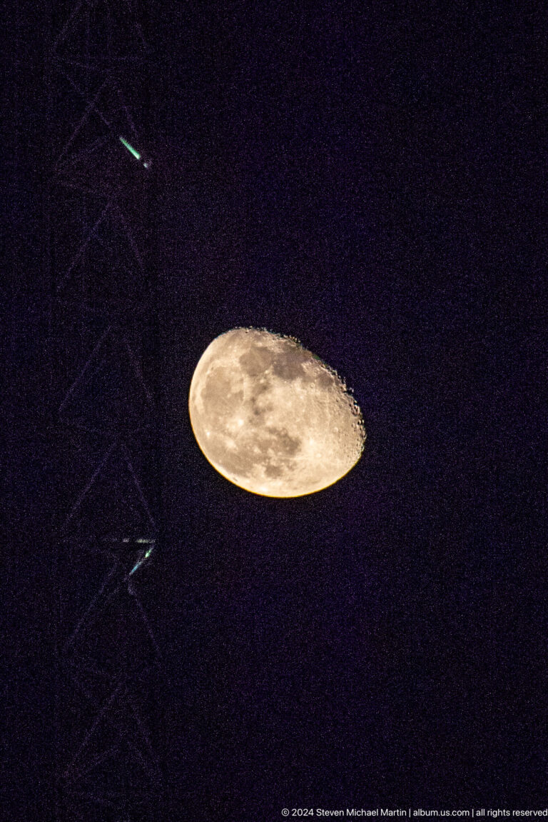 Full moon framed by dark dome lattice at Louvre Abu Dhabi.