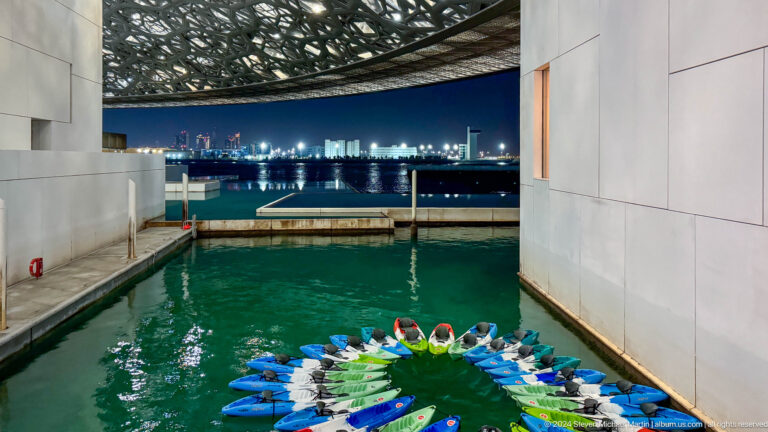 Colorful floating installation in green pool at Louvre Abu Dhabi.