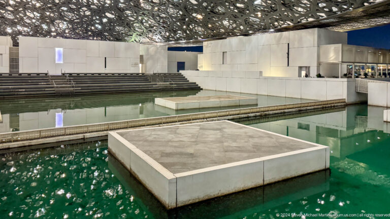 Rectangular platform in green reflecting pool at Louvre Abu Dhabi.