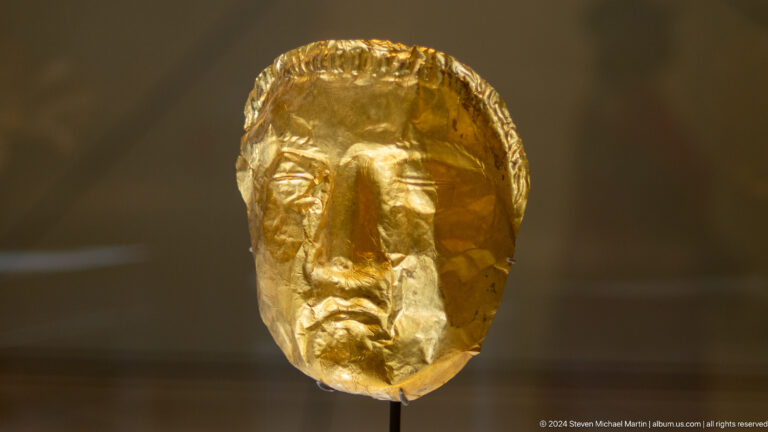 Close view of hammered gold face mask at Louvre Abu Dhabi.