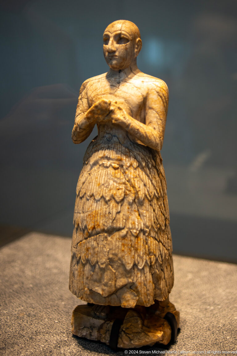 Feathered or scaled lower body of ancient figure at Louvre Abu Dhabi.
