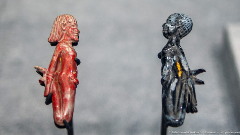 Two small standing figurines viewed from side at Louvre Abu Dhabi.