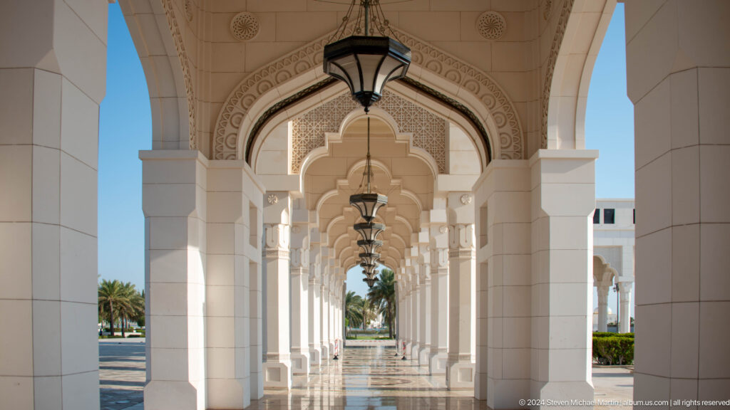 Symmetrical palace arcade opening toward gardens.