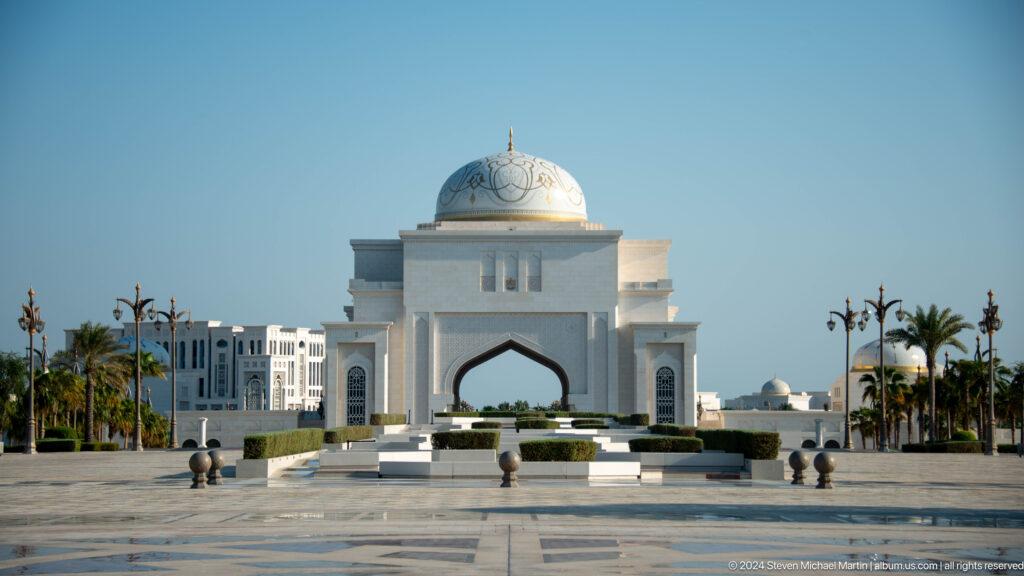 Distant domed palace gateway across formal approach.
