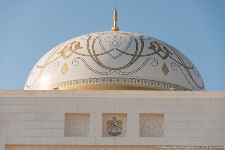 White dome decorated with gold arabesque patterns.