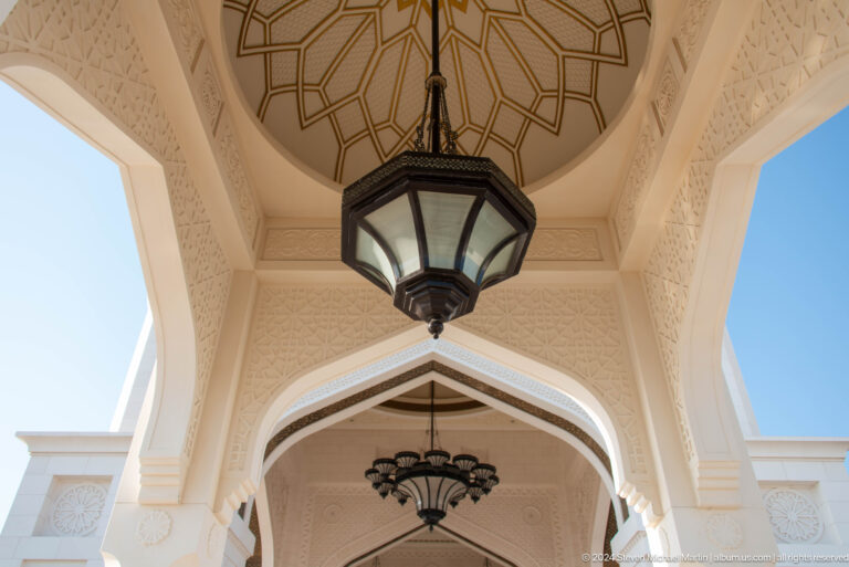 Hanging lantern beneath carved exterior arch.