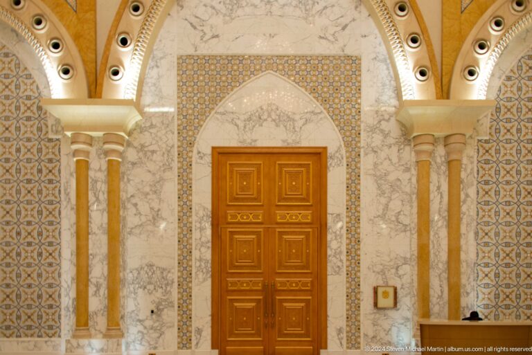Carved wooden door framed by intricate wall decoration.