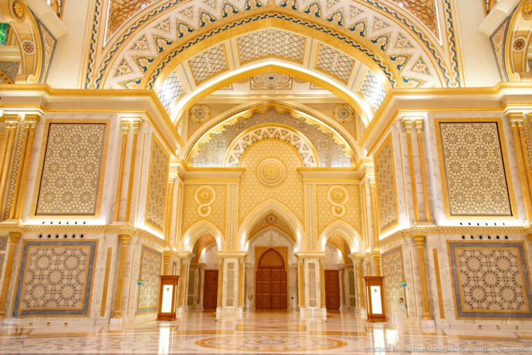 Symmetrical gold-trimmed corridor with pointed arches.