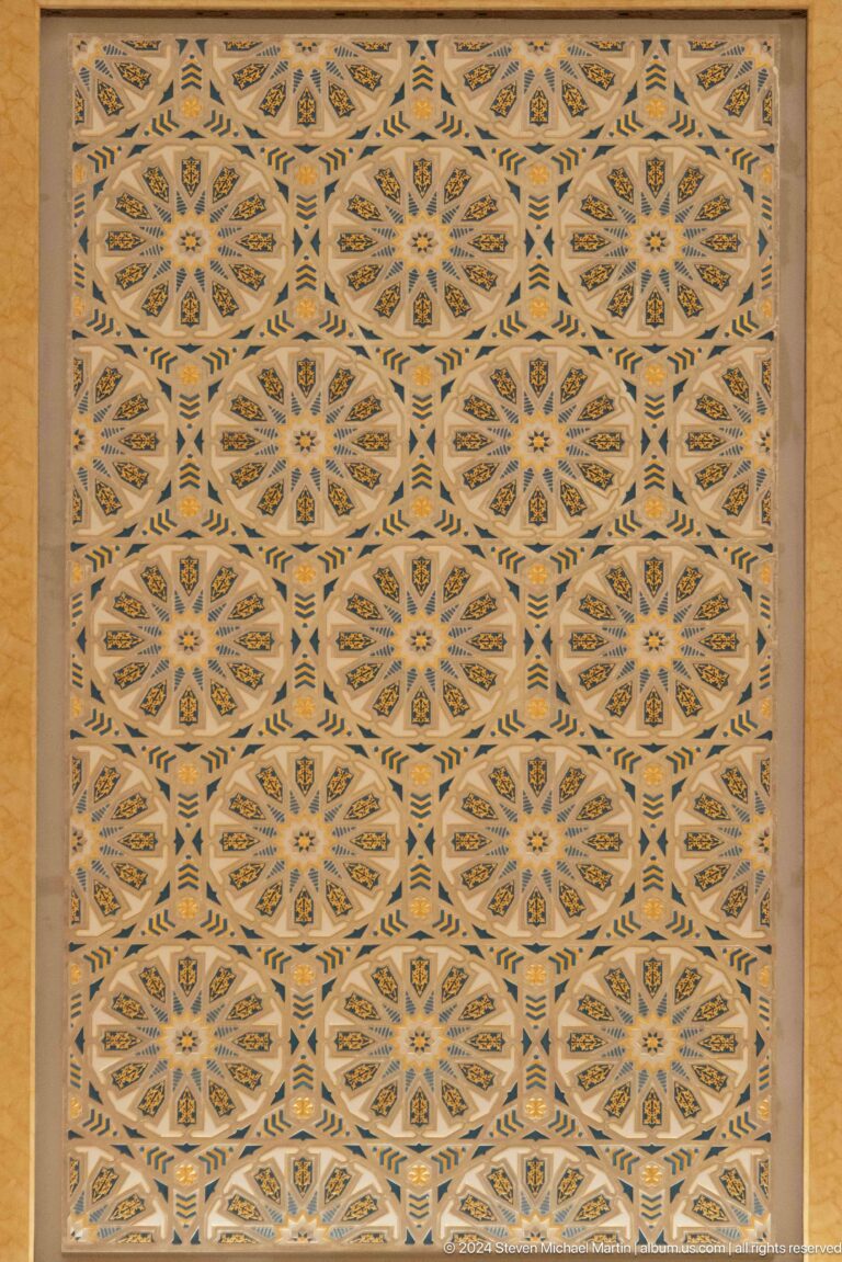 Dense repeating rosette pattern on carved surface.