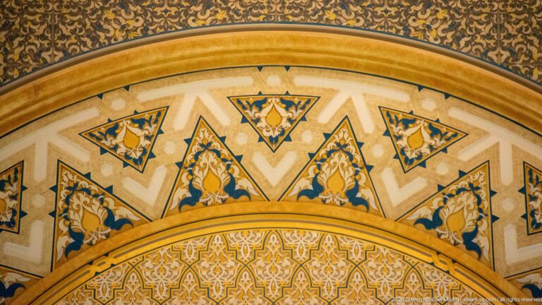 Painted arch band with triangular floral panels.