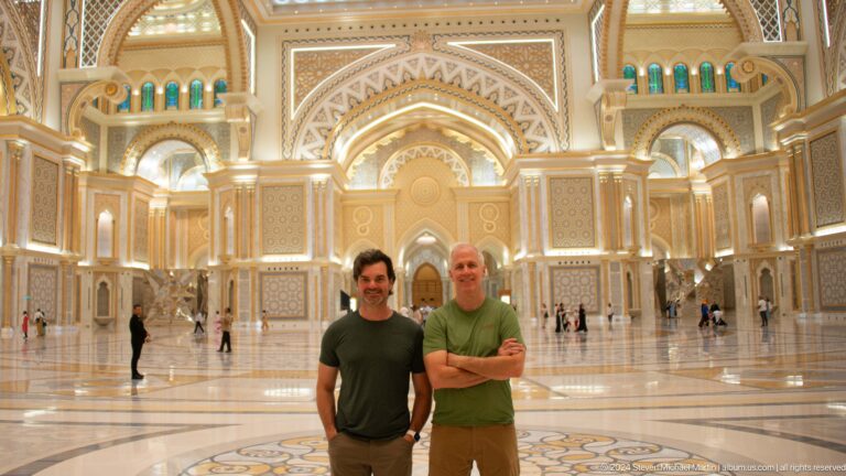 Two visitors posing inside great hall.