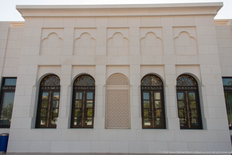 White palace wall with arched windows.