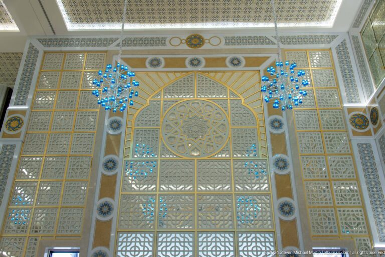 Large patterned wall with blue hanging ornaments.