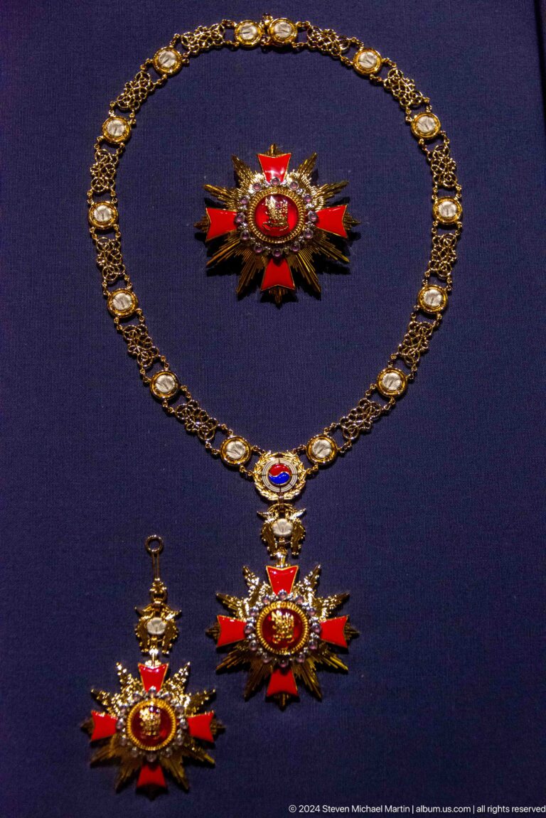 Jeweled ceremonial necklace on dark background.